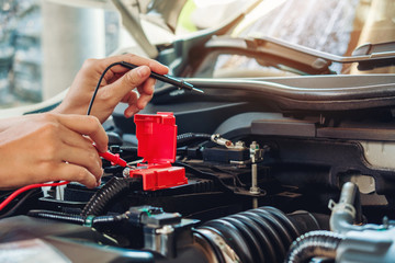 Hands of car mechanic working in auto repair service.