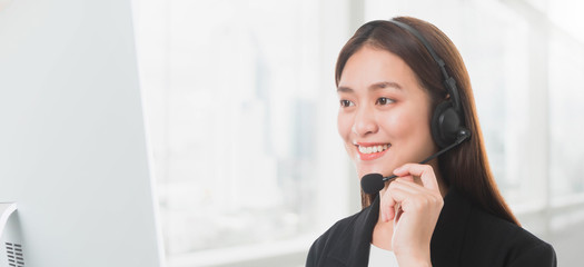 Portrait of Asian beautiful smiling woman customer support phone operator in office space background and copy space.Concept call center job service.