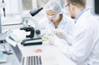 © Seventyfour - Portrait of two modern young scientists doing research studying substances in laboratory, copy space