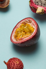 Wall Mural - Half of passion fruit with litchi and dragon fruit on a blue background