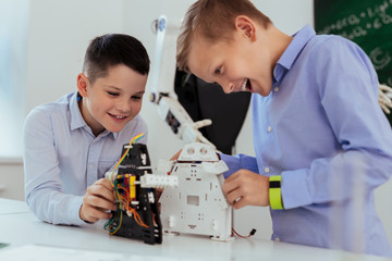 Wall Mural - modern entertainment. positive excited boys smiling while playing with modern robots