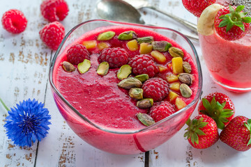 Sticker - Raspberry and strawberry smoothies garnished with fresh fruit and pistachio nuts . Healthy breakfast idea.