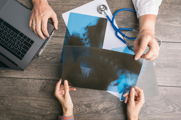 Medical x-ray consultation. Doctors and patients hands on the table. Top view. Professional health care. consultation of the problem of the spine. radiograph film diagnosis