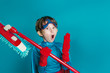 Portrait of young boy cleaning super hero hold mop on blue background