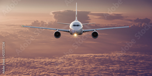 Fotomural Commercial airplane flying above clouds.