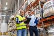 © Syda Productions - wholesale, logistic business and people concept - manual worker and businessman with clipboards at warehouse