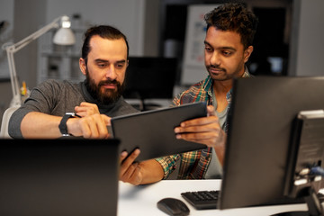 deadline, technology and people concept - creative team with tablet pc computer working together late at night office