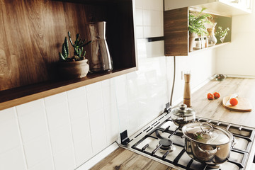 Wall Mural - Cooking on Modern Kitchen  in scandinavian style. stylish grey kitchen interior design with modern furniture and stainless steel appliances. wooden countertop, steel stove, board,knife and spices