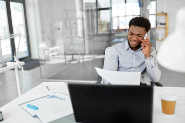 Sticker - business, people, communication and technology concept - smiling african american businessman with papers and laptop computer calling on smartphone at office