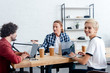 © LIGHTFIELD STUDIOS - smiling young business colleagues working with digital devices