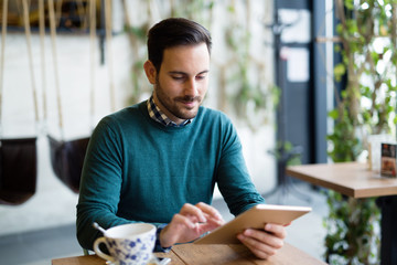 Portrait of young attractive man using tablet