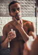 Young Afro-American Man Applying Aftershave Lotion