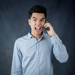 © narongchaihlaw - Portrait handsome young asian man wearing a blue shirt holding smart phone feeling stressful isolated on black background. Businessman concept. Asia people.