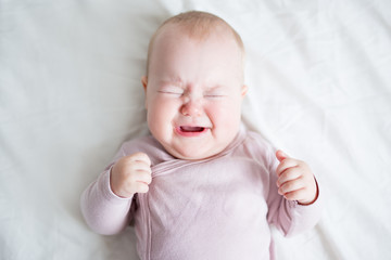 little baby girl crying on the bed