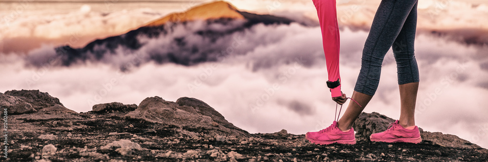 Runner woman getting ready for trail run in volcano altitude mountains background tying up running shoes laces. Fitness and sports motivation healthy lifestyle. Banner panorama. - obrazy, fototapety, plakaty 