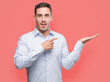 © Krakenimages.com - Handsome young businessman amazed and smiling to the camera while presenting with hand and pointing with finger.