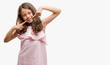 © Krakenimages.com - Brunette hispanic girl wearing pink dress smiling confident showing and pointing with fingers teeth and mouth. Health concept.