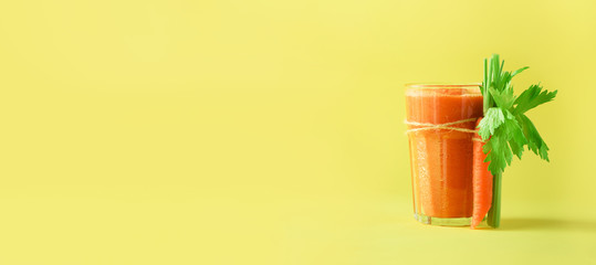 Wall Mural - Fresh organic carrot juice with carrots, celery on yellow background. Vegetable smothie in glass. Banner. Copy space. Summer food concept. Healthy detox eating, alkaline diet