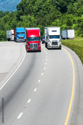 Fotografija Squadron of Heavy Trucks On Interstate With Copy Space