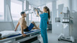 © Gorodenkoff - In the Hospital, Man Sitting on a Bed, Female Technician adjusts X-Ray Machine for Scanning His Leg for Injury. Scanning for Fractures, Broken Limbs, Injuries, Cancer or Tumor. Modern Hospital.