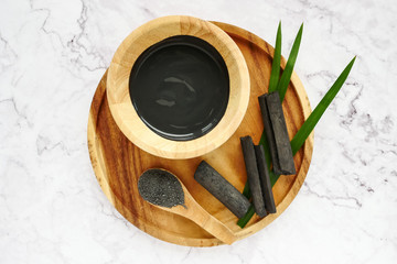 Facial mask and scrub by activated charcoal powder on marble table