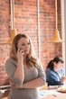 © Wavebreak Media - Businesswoman talking on smartphone while standing in office