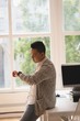 © Wavebreak Media - Businessman looking at watch while sitting on table in office