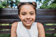 © LIGHTFIELD STUDIOS - portrait of smiling child looking at camera while sitting on wooden bench
