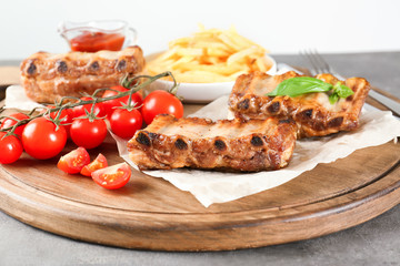 Sticker - Wooden board with delicious grilled ribs and vegetables on table