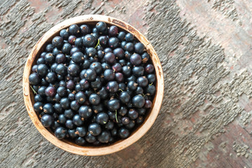 Poster - Bowl of blackcurrant on the wooden board