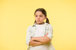 © be free - I do not want to see you. After dispute. Girl serious face offended yellow background. Kid unhappy looks strictly. Girl folded arms on chest looks serious. Sensitive girl not want to talk