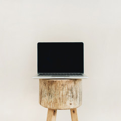 Front view of laptop on wooden stool. Lifestyle blog hero header. Creative blog or social media background. Mock up.