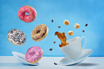 Wall Mural - Flying cup of coffee with multicolored donuts