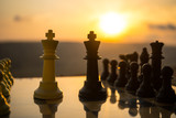 Fototapeta Tęcza - chess board game concept of business ideas and competition and strategy ideas. Chess figures on a chessboard outdoor sunset background.