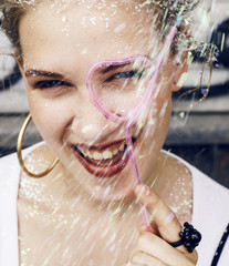 young pretty party girl smiling covered with glitter tinsel, fas