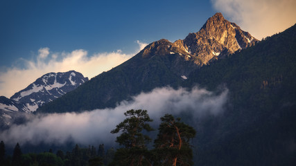 Wall Mural - Beautiful nature landscape of mountains at sunset. Peak is illuminated by golden sun light