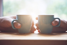 Couple With Two Cups Of Morning Coffee On Sunrise Light
