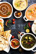 Assorted indian food for lunch or dinner, rice, lentils, paneer, dal makhani, naan, chutney, spices over moody background. selective focus
