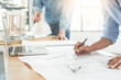 © snowing12 - Close-up Of Person's engineer Hand Drawing Plan On Blue Print with architect equipment, Architects discussing at the table, team work and work flow construction concept