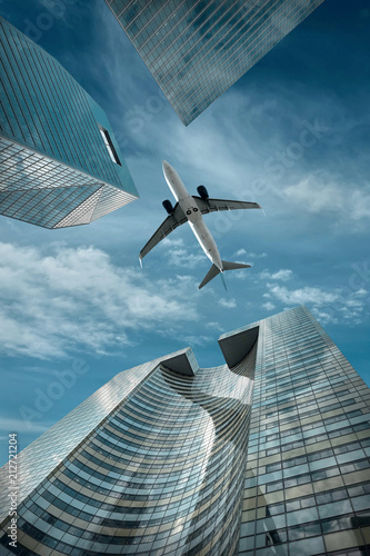 Dekoracja na wymiar  samolot-przelatujacy-nad-nowoczesnymi-biurowcami-ze-szkla-i-stali-w-poblizu