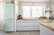Neo mint fridge standing in real photo of bright kitchen interio