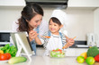 © makistock - Mother with her daughter preparing lunch in the kitchen and enjoying together.