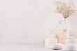 Natural spa cosmetics with white cream, clay, salt, soap and small dry flowers on white wood background, interior, border.