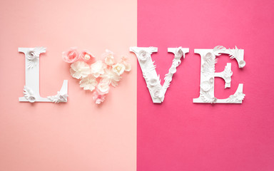 Photo inscription love made of leaves and flowers on pink background