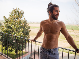 Young man with long hair being in a terrace