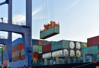 Wall Mural - Port operation, quay crane discharging container from vessel onto truck.