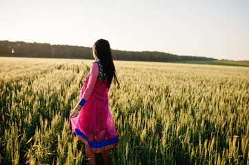 Tender indian girl in saree, with violet lips make up posed at field in sunset. Fashionable india model.