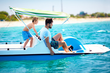 Wall Mural - happy family, father and son enjoy sea adventure on watercraft catamaran at summer vacation