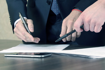 hands of business men and women studying the documents