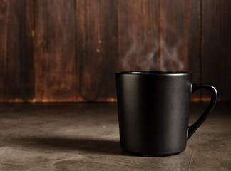 coffee in a black mug with dark wood background